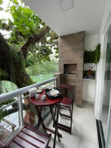 uma varanda com uma mesa, cadeiras e uma árvore em Paraíso na Ilha da Gigóia no Rio de Janeiro