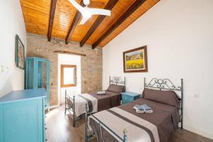 a bedroom with two beds and a wooden ceiling at C,AN ARTUR in Binissalem