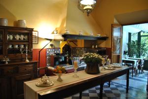 a large kitchen with a long table with flowers on it at Residenza Palazzo Visdomini in Pietrasanta