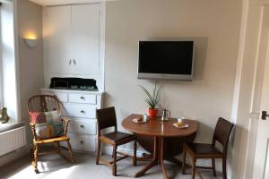 海伯敦桥Stylish studio gem in the heart of Hebden的有桌椅和电视的房间