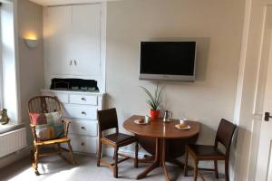 a room with a table and chairs and a tv at Stylish studio gem in the heart of Hebden in Hebden Bridge