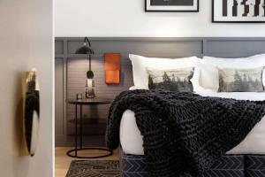 uma cama com um cobertor preto e branco e uma mesa em QT Queenstown em Queenstown