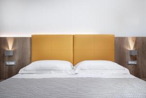 a bedroom with a large bed with a yellow headboard at Hotel San Teodoro in San Teodoro
