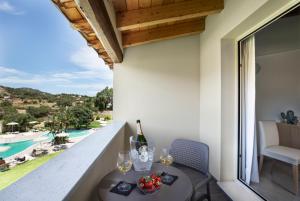 a room with a balcony with a table and wine glasses at Hotel San Teodoro in San Teodoro