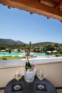 a bottle of wine and two glasses on a table at Hotel San Teodoro in San Teodoro