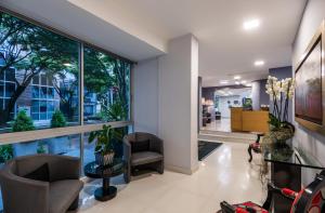 a living room filled with furniture and a large window at Hotel Asturias Medellin in Medellín