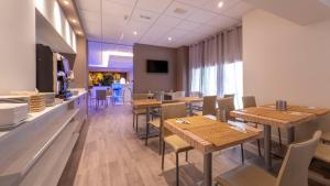 a restaurant with wooden tables and chairs and a counter at Hotel San Marco in Reggio Emilia