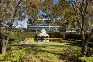 um gazebo num parque com um edifício ao fundo em Rydges Norwest Sydney em Baulkham Hills