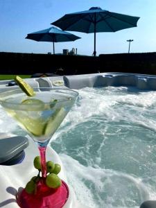 a martini glass sitting on a table next to a swimming pool at Villa Black&White in Kastel Sucurac