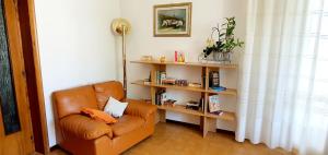 a living room with a chair and a book shelf at Villa nella collina Francavillese in Francavilla al Mare