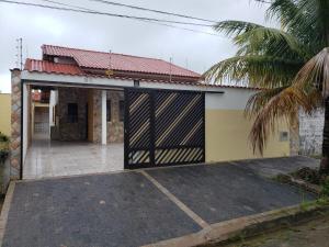 a building with a garage door with a palm tree at Casa em Peruíbe in Peruíbe