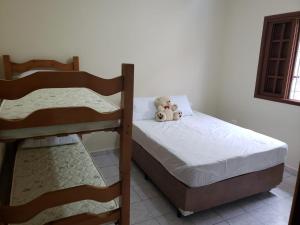 two teddy bears sitting on a bed in a room at Casa em Peruíbe in Peruíbe +5 photos
