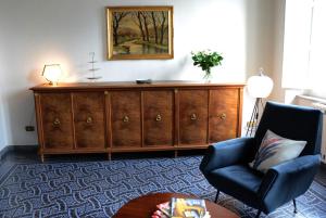 - un salon avec une grande armoire en bois et une chaise dans l'établissement Le Muse, à Pise