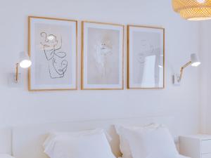 four drawings of cats on a wall above a bed at AL - Apartamento Miratlântico in Quarteira