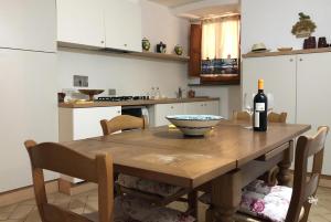 una cocina con una mesa de madera y una botella de vino en Alberi Flat, en Volterra