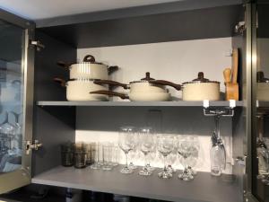 a shelf with wine glasses and pots and pans at Flat Garden Itaipava in Itaipava