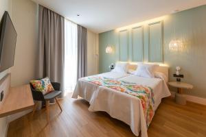 una habitación de hotel con una cama grande y una silla en La Puerta de Nerja BOUTIQUE - Adults Recommended en Nerja