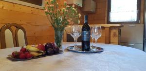 a bottle of wine and a plate of fruit on a table at Domek letniskowy Michałówka in Łeba