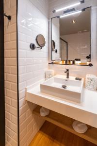 a bathroom with a white sink and a mirror at La Puerta de Nerja BOUTIQUE - Adults Recommended in Nerja