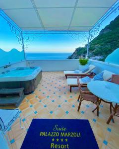 Camera con vasca da bagno, tavolo e sedie. di Palazzo Marzoli charme Resort - Small Luxury Hotel a Positano