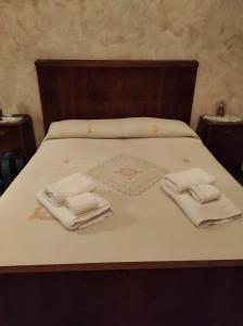 ein Bett mit zwei weißen Handtüchern darüber in der Unterkunft Casa "Albero Verde" in Raffo