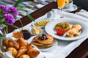 a table with plates of pastries and other breakfast foods at ATECA Hotel Suites Tashkent in Tashkent