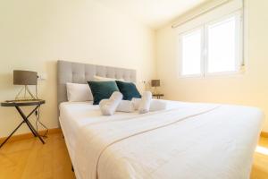 duże białe łóżko w pokoju z oknem w obiekcie MyFlats Luxury Navas w Alicante