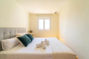 1 dormitorio con 1 cama blanca grande y toallas. en MyFlats Luxury Navas, en Alicante