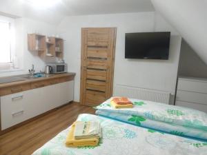 a room with a kitchen and a bed with towels on it at Zemianska Kúria Vachtár in Kráľová Lehota