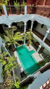 una vista aérea de una piscina en un edificio con palmeras en Riad Fabiola Et Spa, en Marrakech