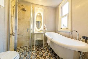 a bathroom with a tub and a shower and a sink at Meroddi Barnathan Hotel in Istanbul