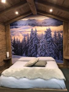 un letto in una stanza con un dipinto sul muro di Best House snc di Elisa Baroni e Beatrice Dei Cas a Bormio