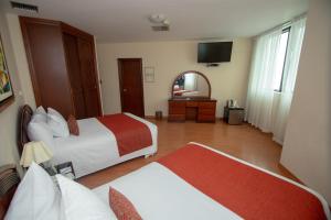 Llit o llits en una habitació de Miraflores Colon Hotel
