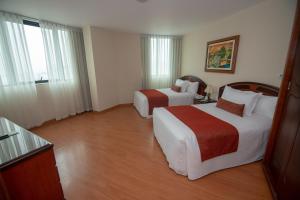 Llit o llits en una habitació de Miraflores Colon Hotel