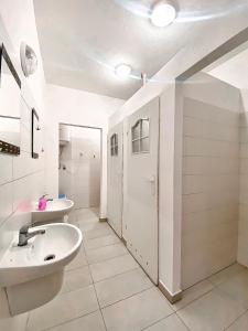 biała łazienka z 2 umywalkami i lustrem w obiekcie Schronisko Młodzieżowe PTSM "Alko" w mieście Rzeszów