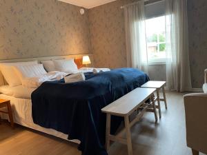 a bedroom with a large bed and a table at Brändö Bike and Bed in Brändö