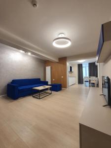 a living room with a blue couch and a table at Aparthotel Nevada - Apartamente in Constanţa