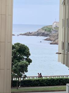 uma vista para o oceano entre dois edifícios em Oxford Suites Ciudad de la Coruña em La Coruña