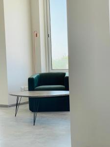 a green couch and a coffee table in a room at Hotel VIU57 in Mellieħa