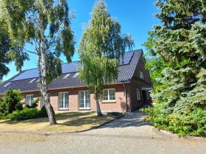 a brick house with solar panels on the roof at Gästehaus Weinberge in Elsterwerda