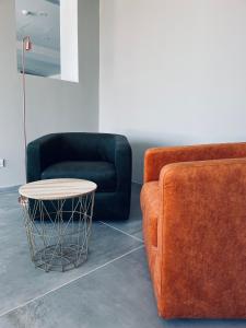 a living room with two chairs and a coffee table at Hotel VIU57 in Mellieħa