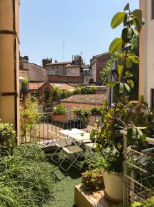 um jardim no último piso com mesas e cadeiras num edifício em Hôtel Croix Baragnon em Toulouse