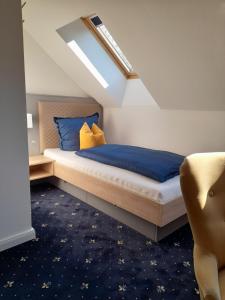 a bedroom with a bed with blue and yellow pillows at Gästehaus Weinberge in Elsterwerda