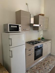 una cucina con frigorifero bianco e forno a microonde di Casa San Paolo a Sarnico
