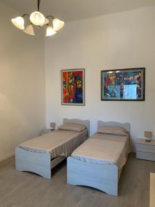 2 letti in una camera con dipinti alle pareti di Casa San Paolo a Sarnico