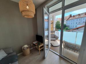 a living room with a view of a balcony at PLUSK Apartments Mrągowo in Mrągowo