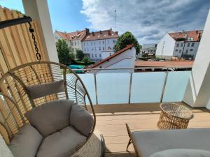 krzesło na balkonie z widokiem na miasto w obiekcie PLUSK Apartments Mrągowo w mieście Mrągowo
