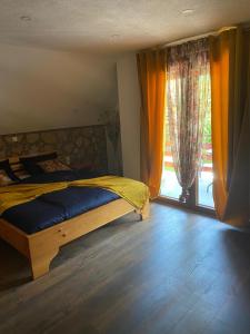 a bedroom with a bed and a large window at PLITVICE FAIRYTALE in Plitvička Jezera