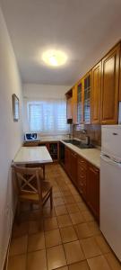 una cucina con tavolo e frigorifero bianco di Apartments Golub a Krk