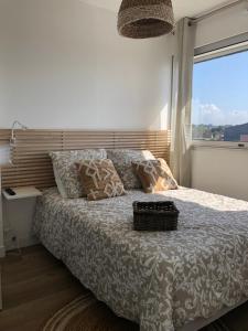 a bedroom with a large bed with a window at Le 84 in Courseulles-sur-Mer